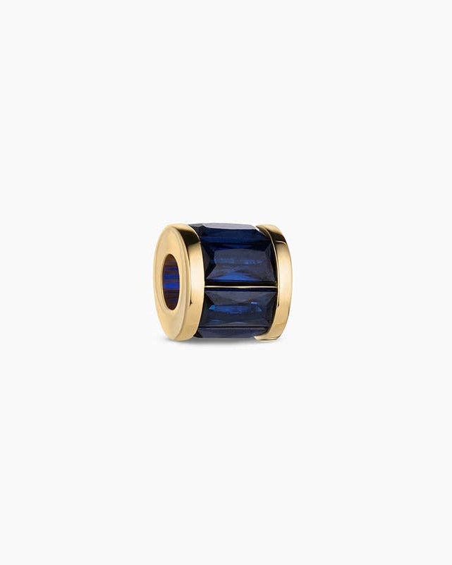 Gold ring with a blue gemstone on a white background