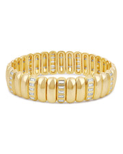 A gold tennis bracelet with a segmented, rounded link design and rows of small clear baguette and round stones, shown on a plain white background.
