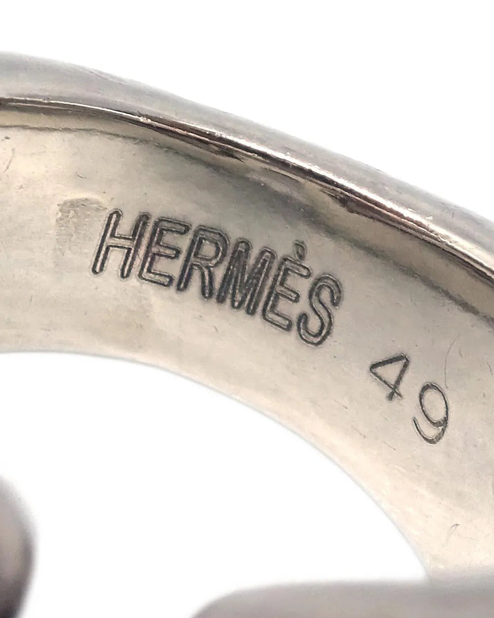 Close-up of a silver Hermès ring with size 49 engraving on a white background