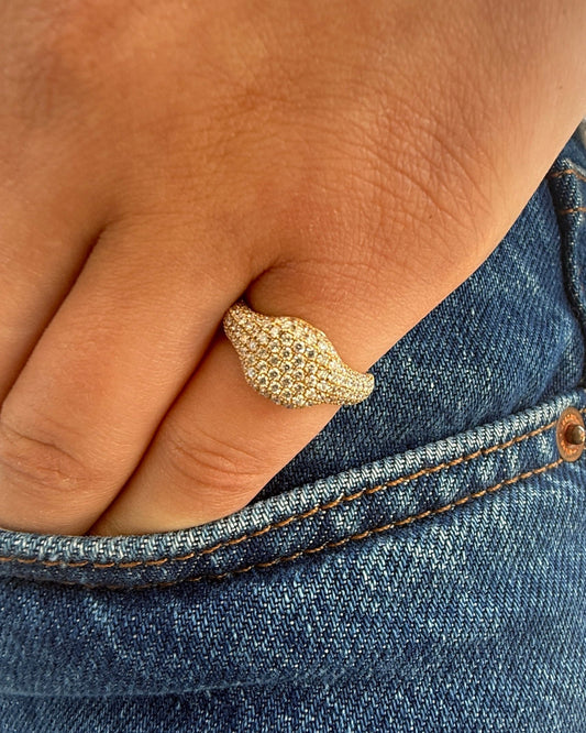Gold ring on a finger with a denim background