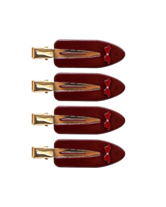 Set of three red hair clips with gold clips on a white background