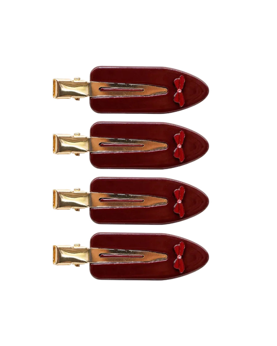 Set of three red hair clips with gold clips on a white background