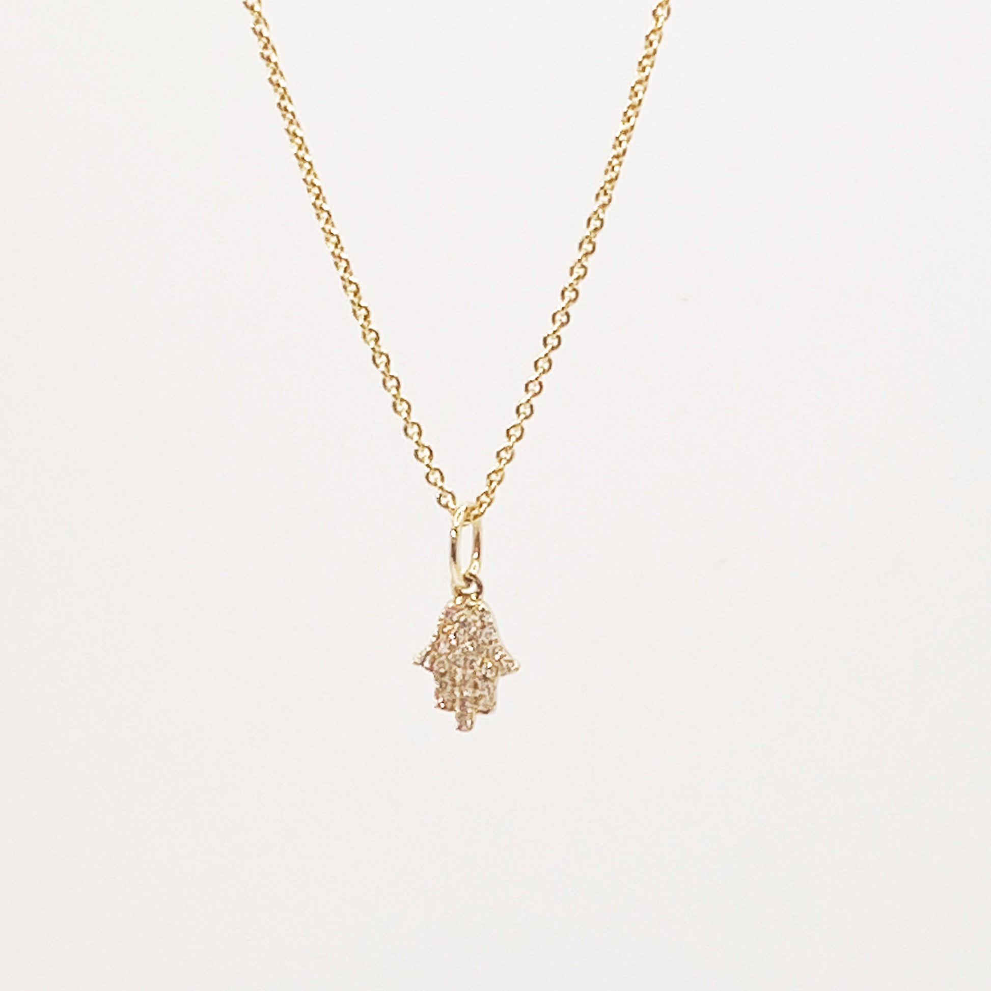 gold chain with gold and diamond hamsa charm  @dylanjamesjewelry.com