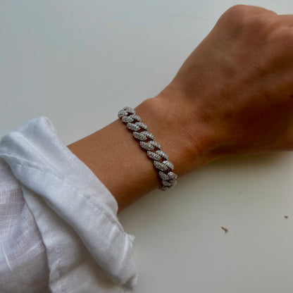 A person wearing the dylanjames PRESLEY Bracelet, a silver chain adorned with sparkling cubic zirconia, on their wrist against a white background.